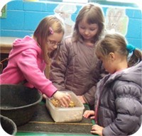 children from Woodhouse West Primary School preparing feed