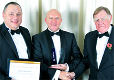 David Jamieson – centre – being presented with his Award by Sir Bernard Ingham, President of the British Franchise Association – right