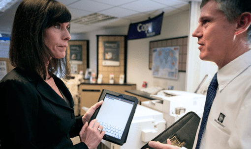 Woman with iPad talking to man