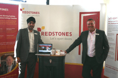 Two men in front of Redstones signage