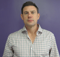 Headshot of man in front of purple wall
