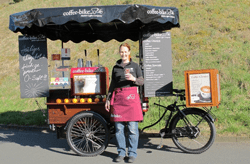 A E E C Be Ad Woman in front of Coffee-Bike cart