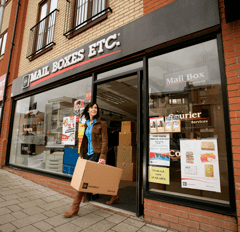 Woman walking out of Mail Boxes Etc. store