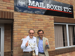 Two men holding Mail Boxes Etc. Award