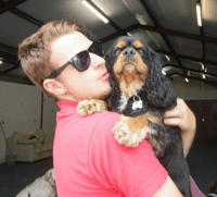 Man in sunglasses holding dog