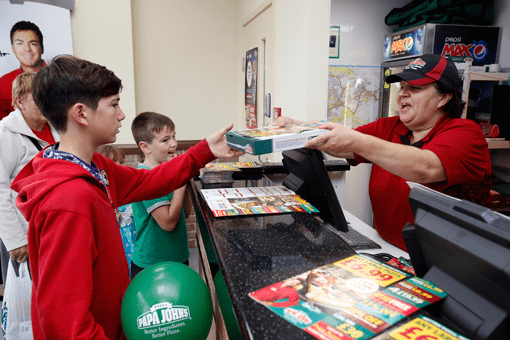 Child handed pizza at Papa John's till