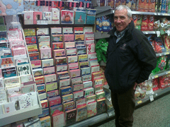 Man standing beside greetings card display