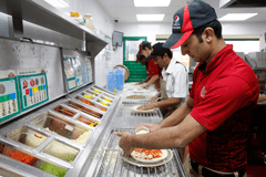 Men making pizza in kitchen