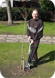 Nigel Hawkin plants a Cherry tree to recognise 5 years of owning Recognition Express Wakefield